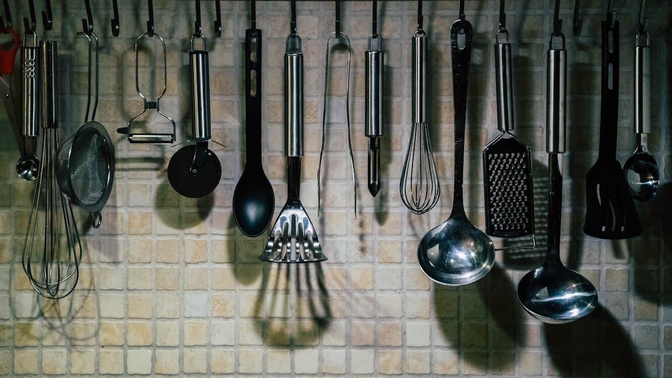 Metal kitchen utensils hanging on a wall