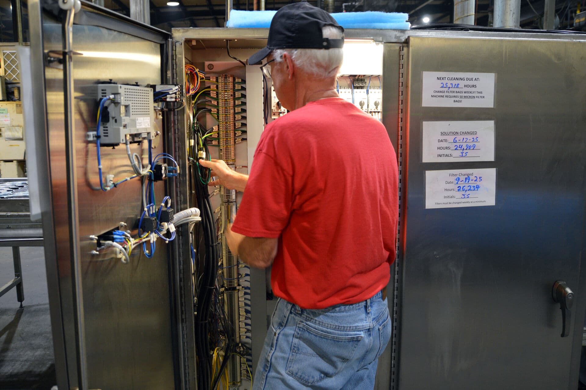 Technician performing maintenance on an industrial washing system